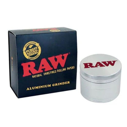 RAW brand aluminium rolling grinder next to its dark blue packaging box, featuring the iconic red RAW logo.