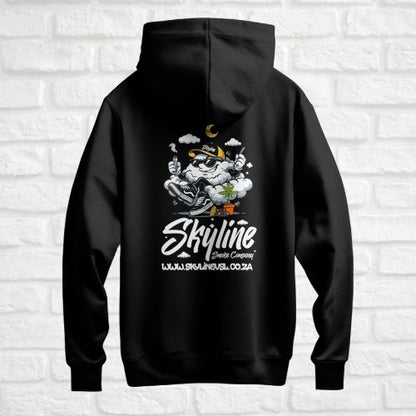 Black hoodie with a graphic design on the back against a white brick wall.